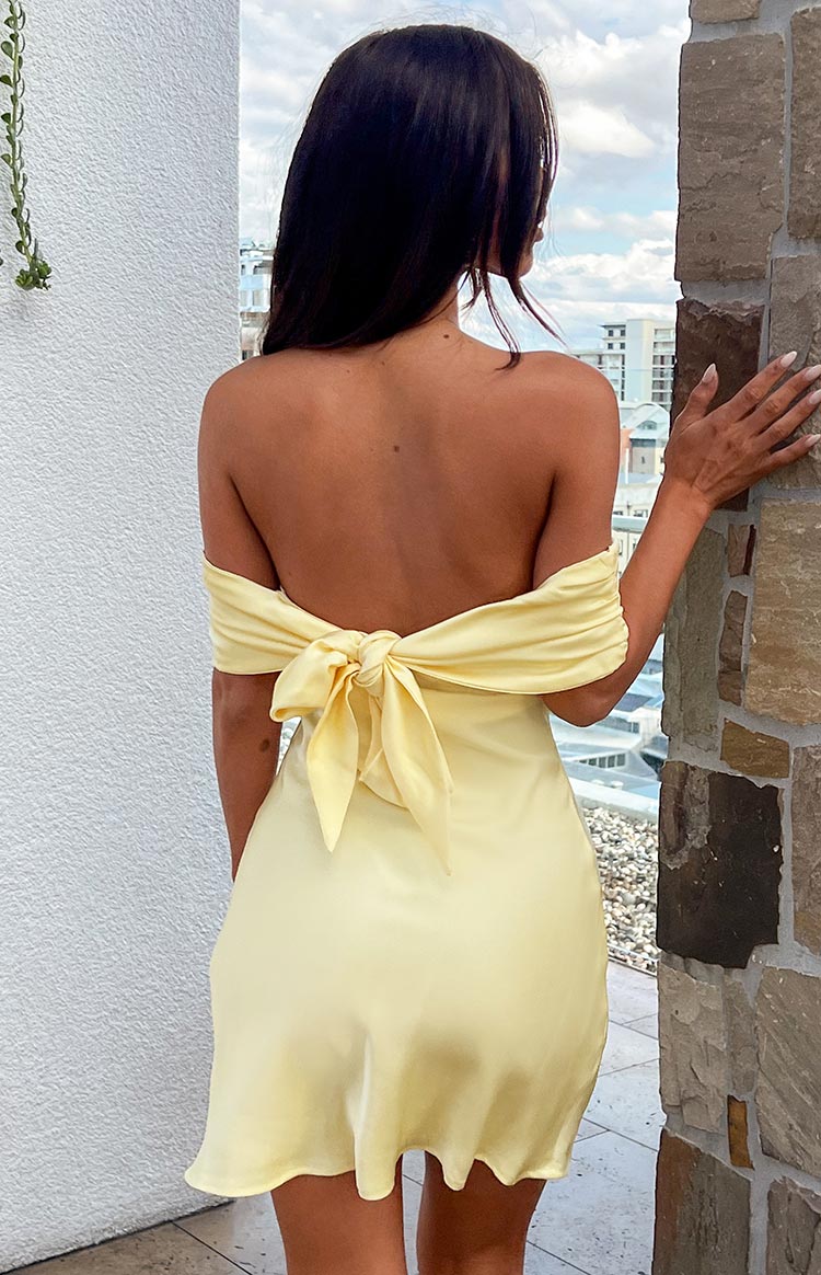 Yellow satin strapless mini party dress with adjustable back tie on brunette model.